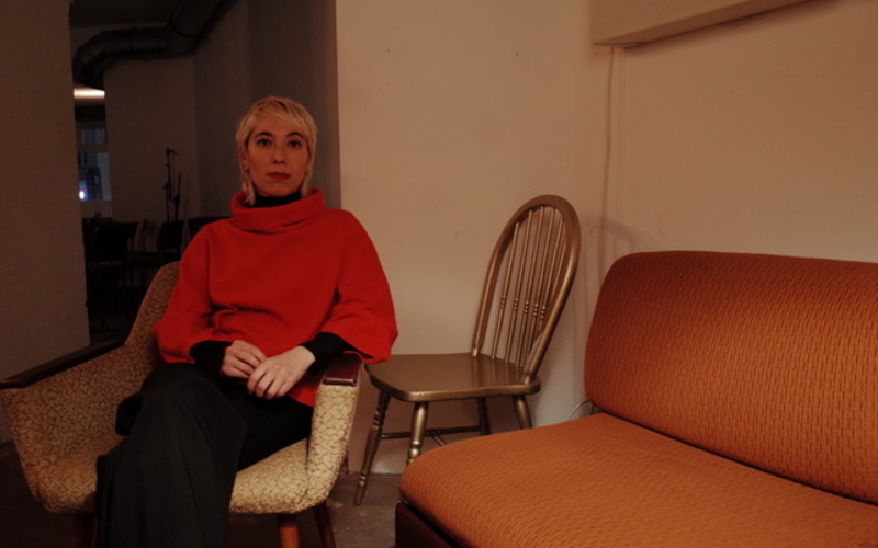 The picture shows a portrait photo of a person sitting on a chair.