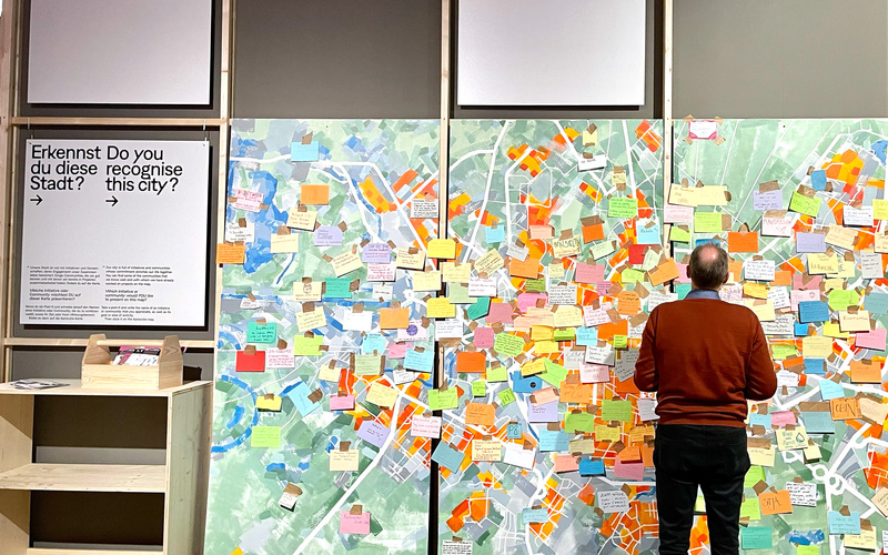 Ein Mann steht vor einer Stadtkarte mit bunten Post-Its