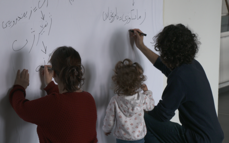 The picture shows three people writing something down.