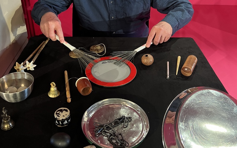 A person sitting at a table with musical instruments.