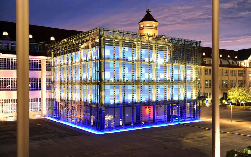 Illuminated glass cube at night.