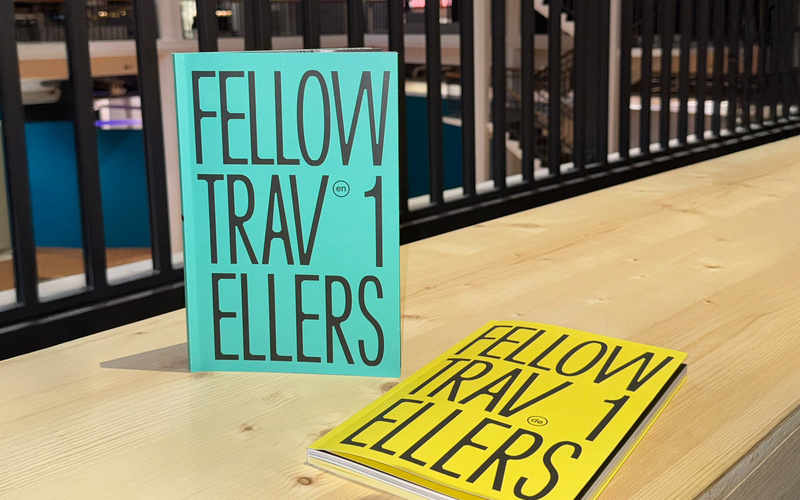 Ein gelbes und ein türkisfarbenes Buch mit der Aufschrift »Fellow Travellers«