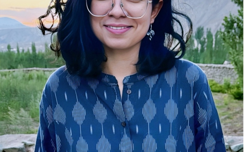 A portrait photo of a person with glasses.