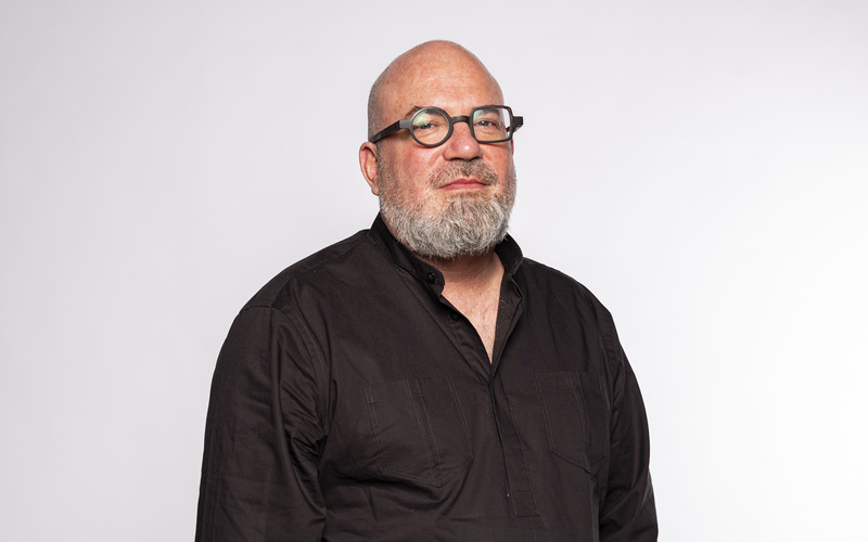 Portrait Marcus Thiel in schwarzem Hemd, in die Kamera schauend