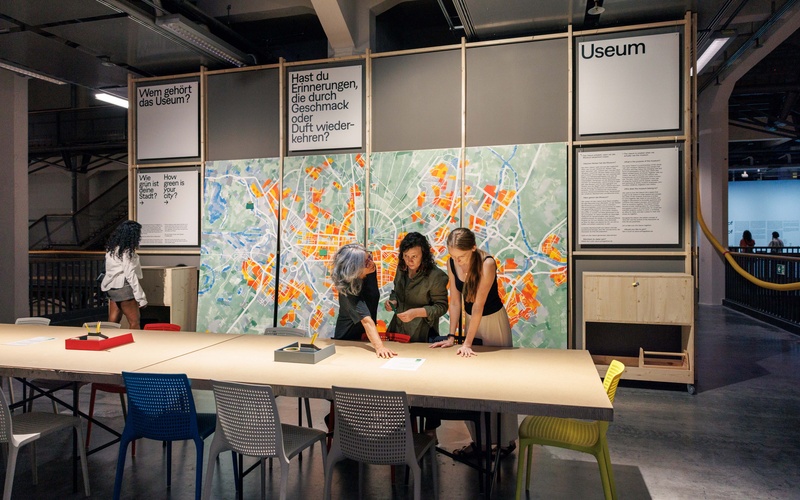 Drei Frauen schauen auf Zettel im USEUM Space des ZKM