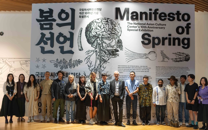 Group photo with all participants in front of the exhibition title