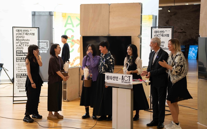 People around a lectern at the opening of the exhibition