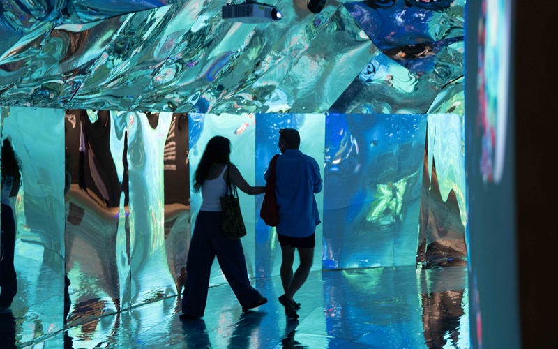 Two people in a turquoise cave passageway