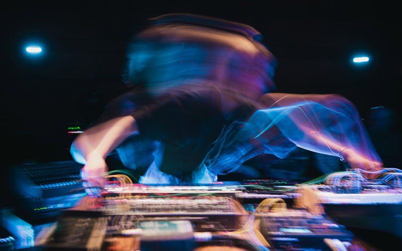 Eine Person am DJ-Pult, Bewegungsunschärfe und Licht