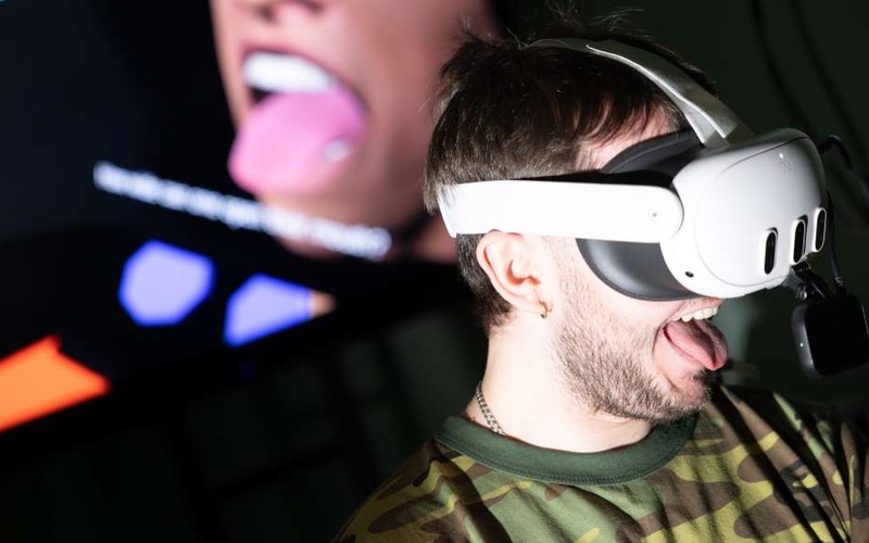 Bild einer Person mit VR-Brille. Die Person streckt ihre Zunge heraus. 