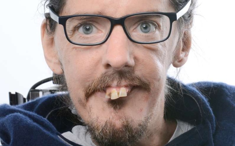 Portrait einer Person vor weißem Hintergrund.