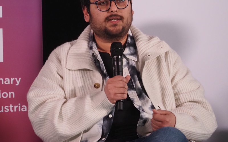 Portrait of a person holding a microphone.