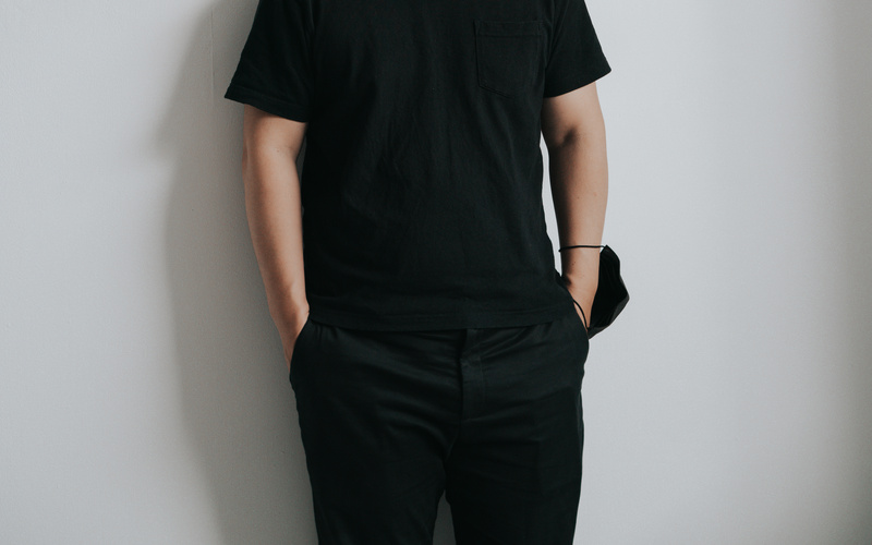 A portrait photo of a person dressed in black. 