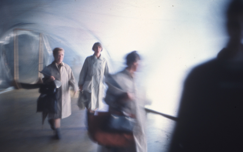 People in white coats stride dynamically across the screen.