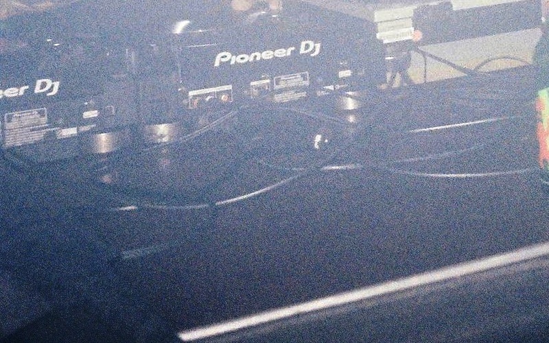 A person can be seen at a DJ desk.  