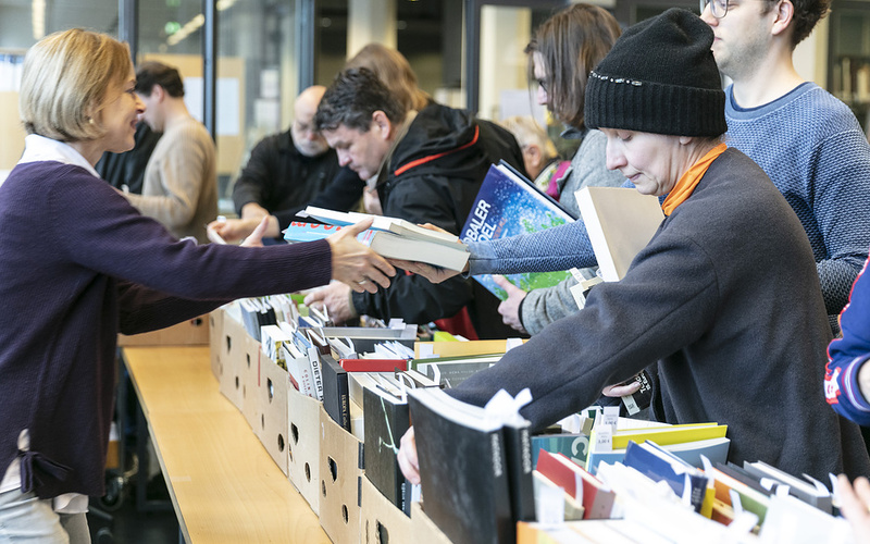 Bild eines Bücherbasars mit Menschen.