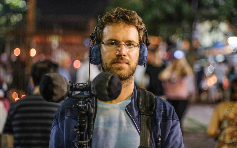 The portrait photograph shows a person with technical equipment.