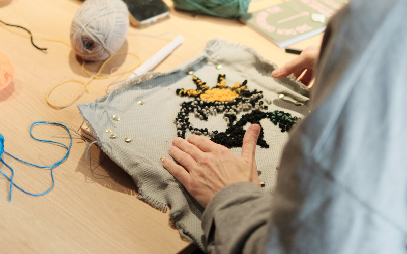 Nahaufnahme von zwei Händen bei einem Tufting-Workshop.