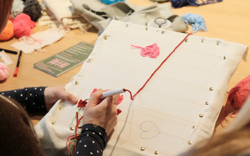 Zwei Personen bei einem Tufting-Workshop.