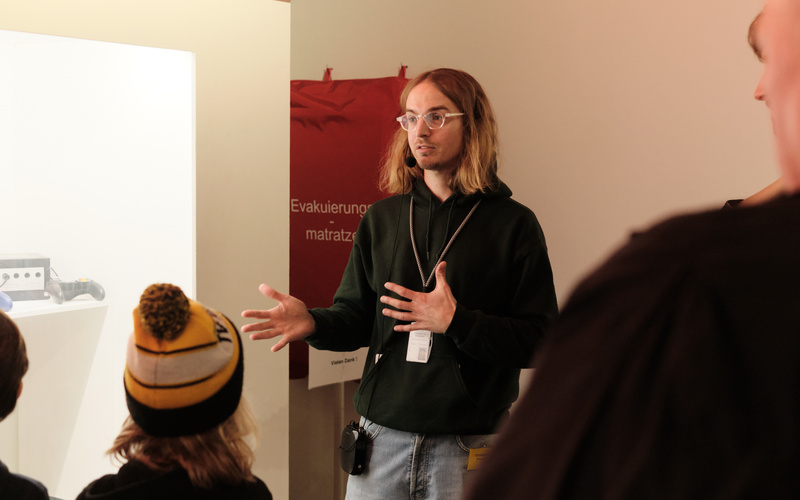 Eine Person steht vor anderen Personen und gestikuliert.