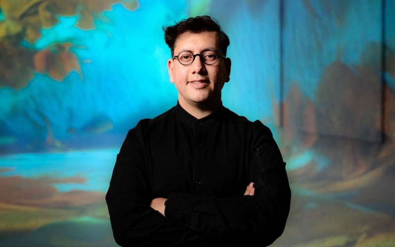 Portrait photo of a person in front of a blue background. 