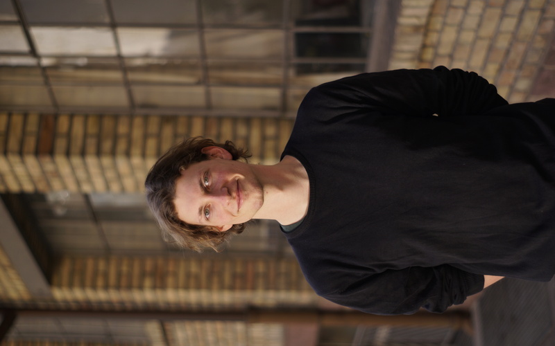 Zu sehen ist ein Portraitfoto von Alex Thelen.