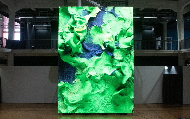 Ein riesiger Bildschirm, auf dem ein abstraktes Kunstwerk zu sehen ist.