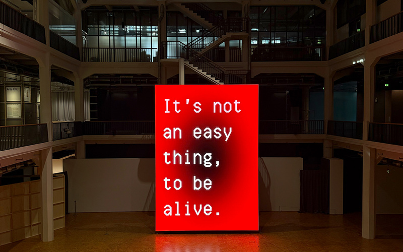 A huge screen displaying Sasha Stiles' work “A Living Poem.”