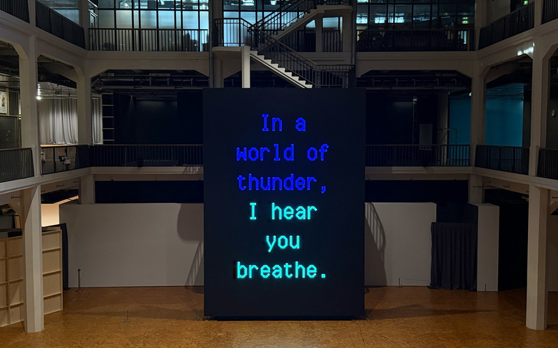 Ein riesiger Bildschirm, der das Werk A Living Poem von Sasha Stiles zeigt.