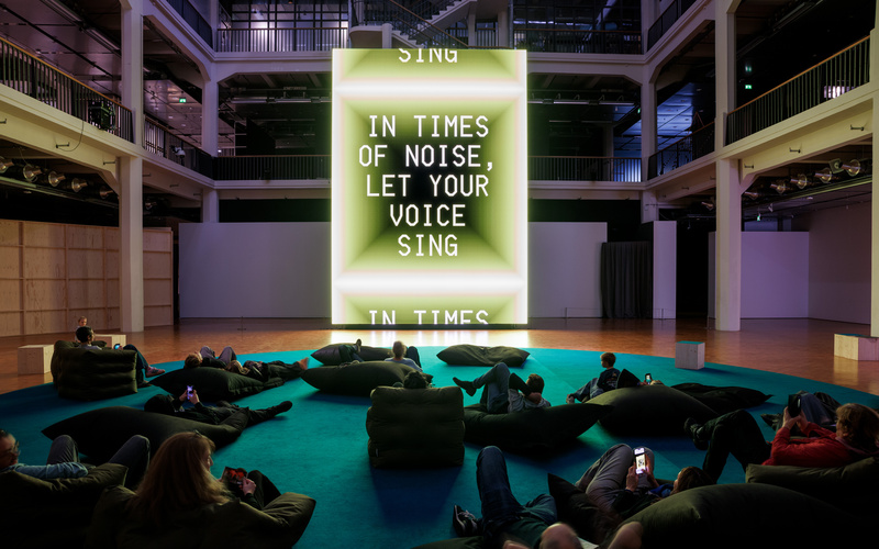 Ein riesiger Bildschirm, der das Werk A Living Poem von Sasha Stiles zeigt.