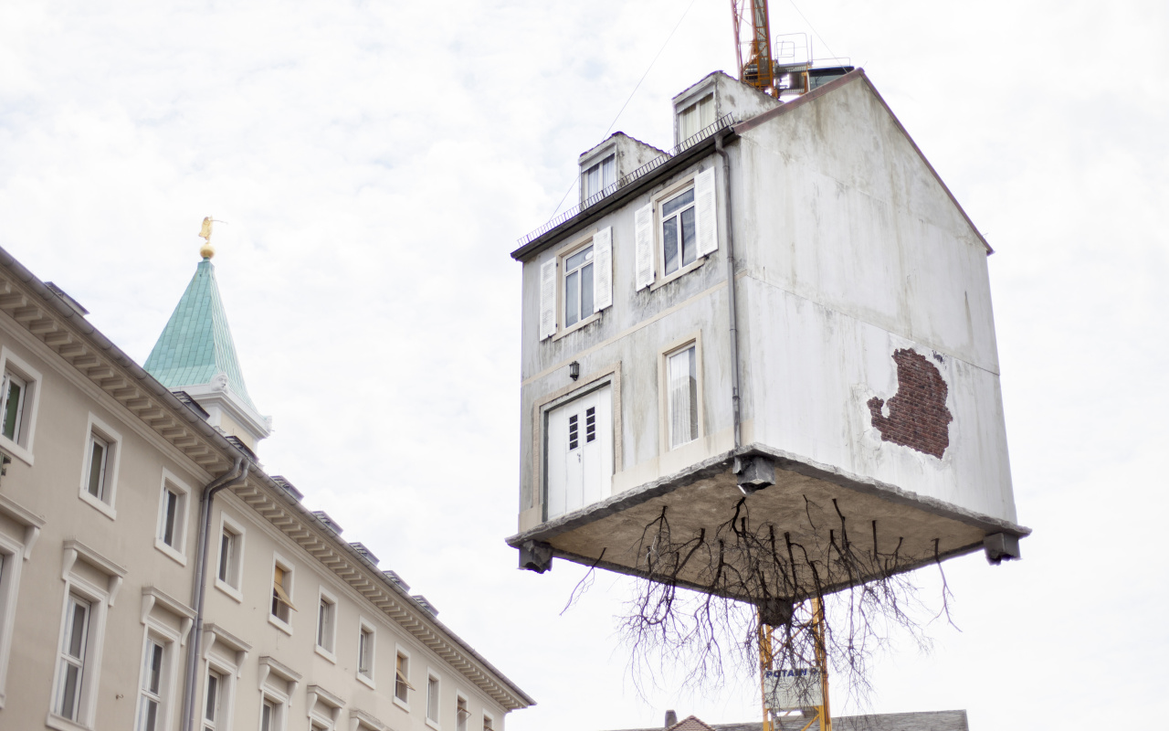 A house hangs on a crane