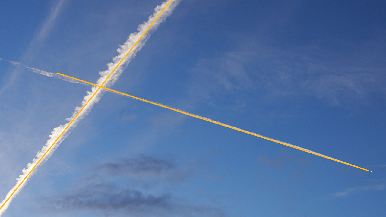 Photo of the sky with crossed contrails of airplanes.