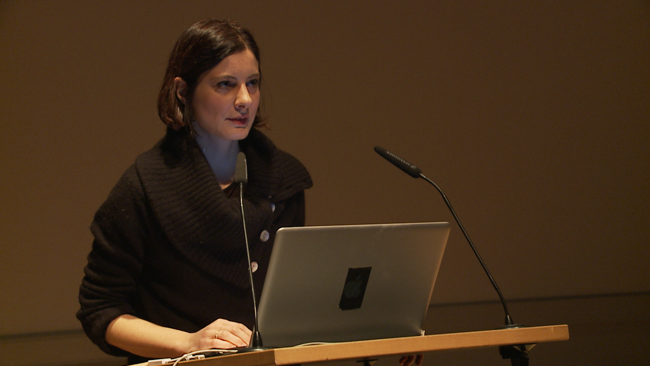 Giulia Vismara stand behind a laptop and gives a lecture.