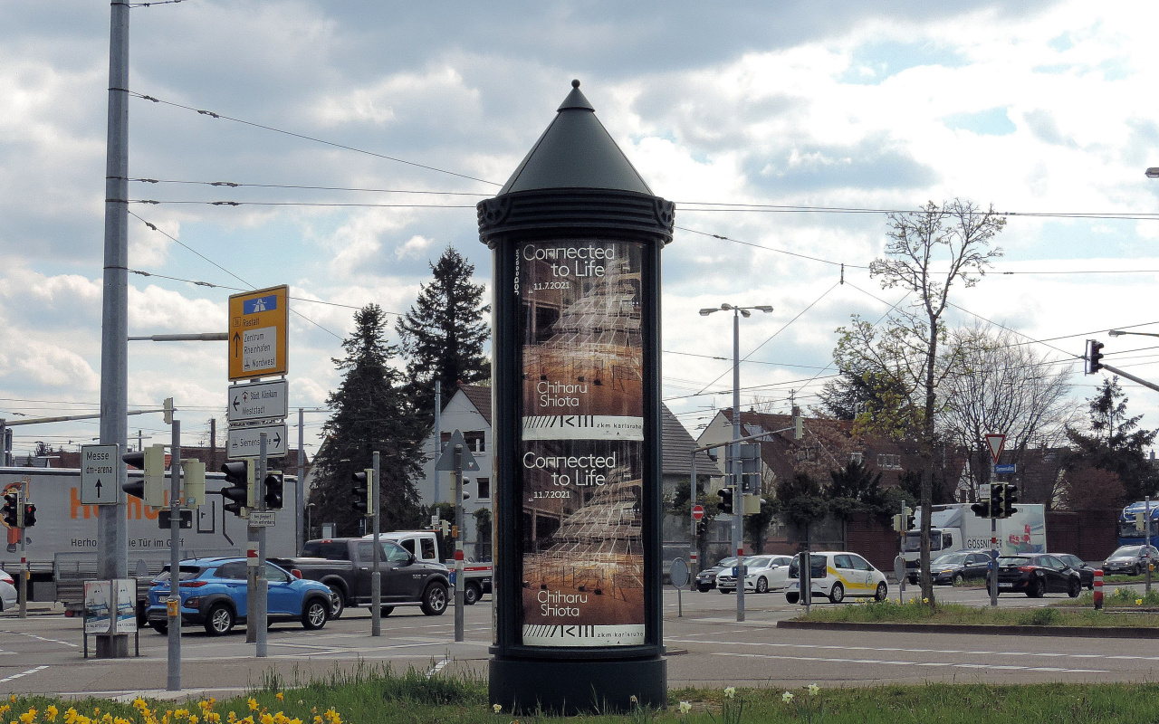 Eine Plakatsäule in Karlsruhe mit Werbung zur Ausstellung »Chiharu Shiota. Connected to Life«.