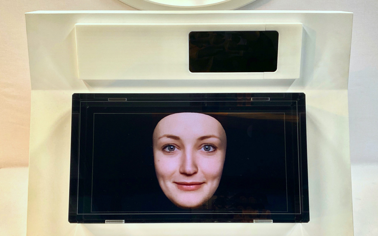 Ein kleiner Bildschirm zeigt ein Frauengesicht vor einem blauem Hintergrund.