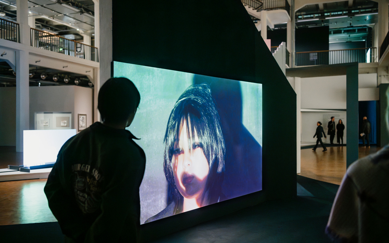 Eine große Leinwand mit einem Video in einer Ausstellung