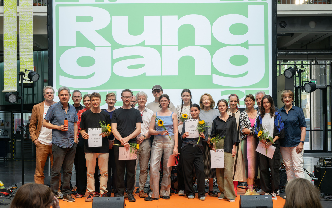 Several people (the jury and the award winners) can be seen on a stage.