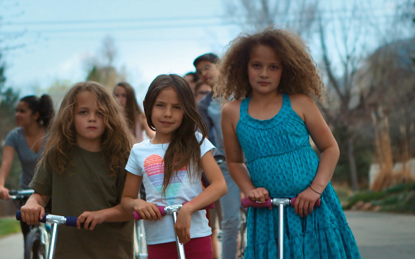 Eine Gruppe Kinder steht auf Rollern und schaut in die Kamera.