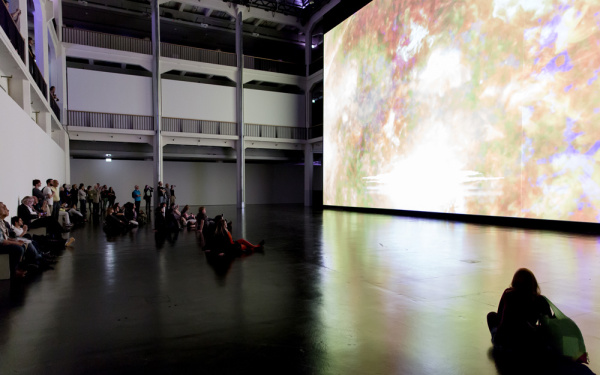 People sitting in front of a huge canvas