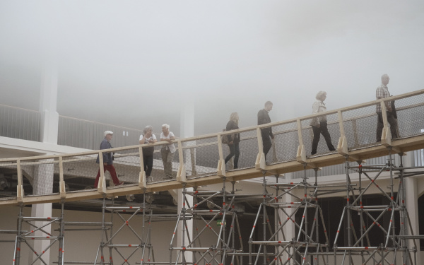 Personen laufen über eine Rampe in eine Wolke