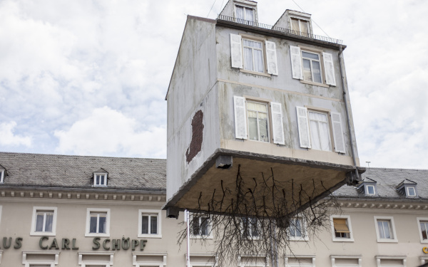 A house hangs on a crane