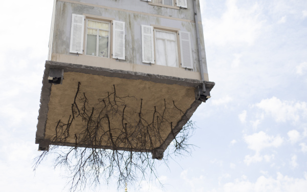 A house hangs on a crane