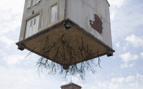 A house hangs on a crane