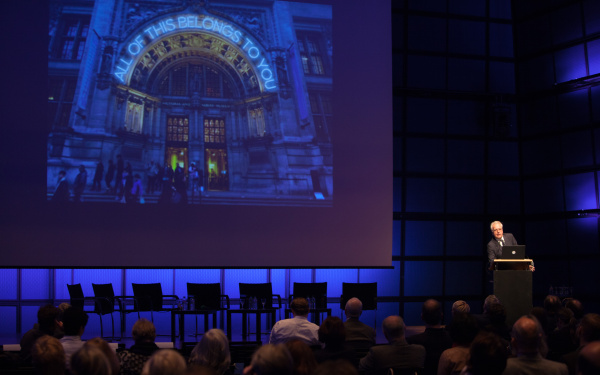 A man standing behind a podium and giving a talk.