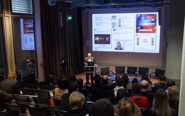 A man standing behind a podium and giving a talk.