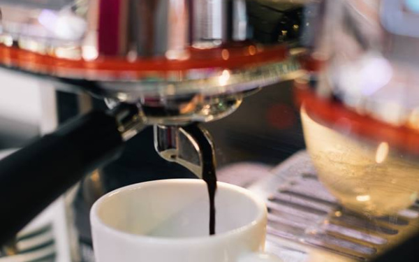 Kaffee kommt aus einer Maschine in die Tasse