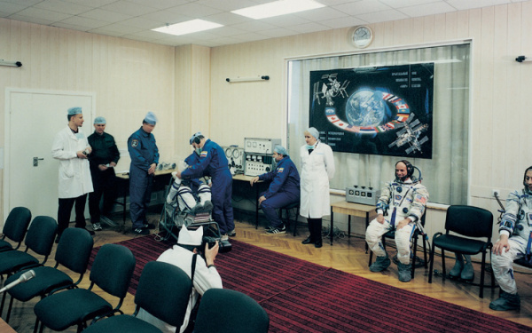 Ein Konferenzraum. Mehrere Astronauten und Mediziner.