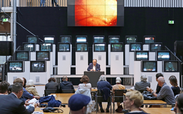 A man sitting in front of several screens