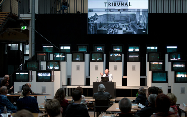 A man sitting in front of several screens