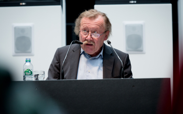 A man on the stage talking to the audience